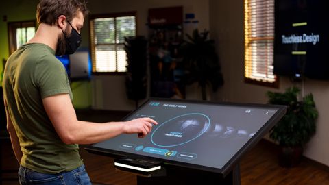 A person interacts touchlessly with an application on an Ideum Drafting touch table.